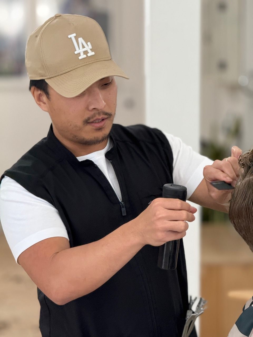 Daniel Lee styling a client's hair in the chair