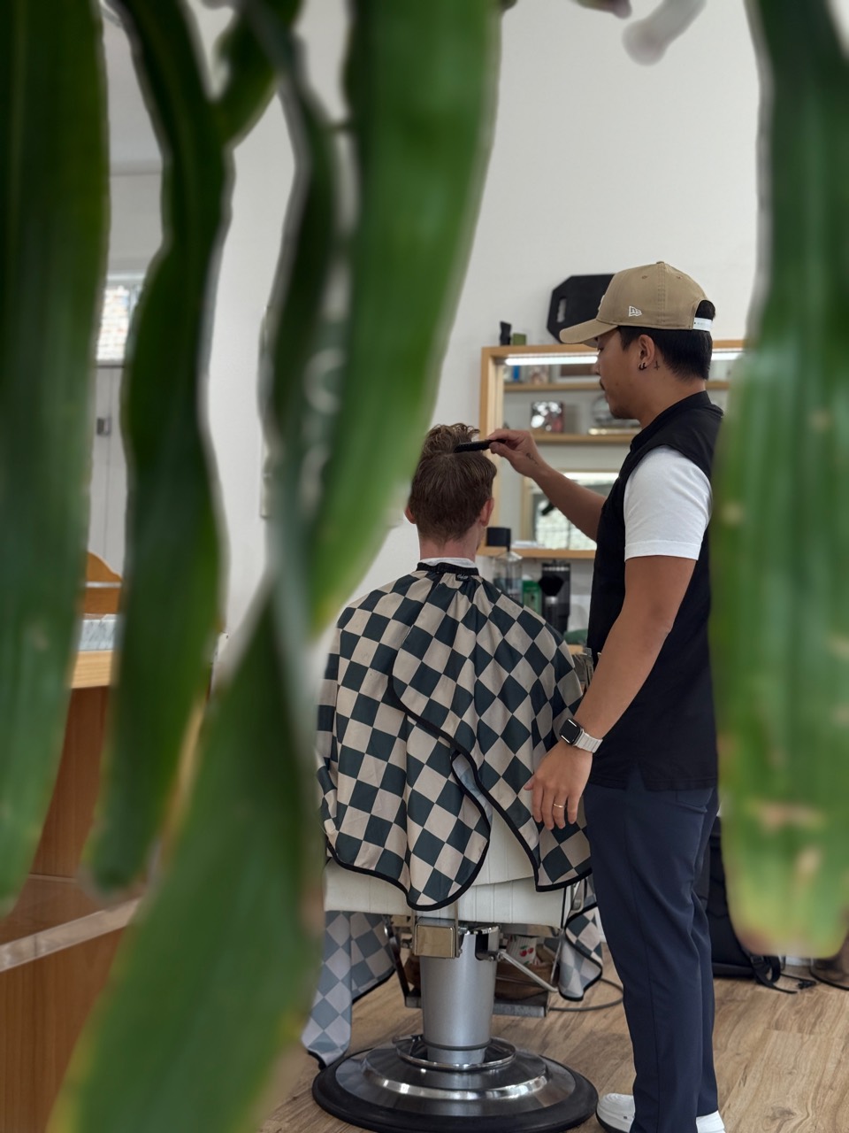 Daniel cutting hair in a calm barber studio.