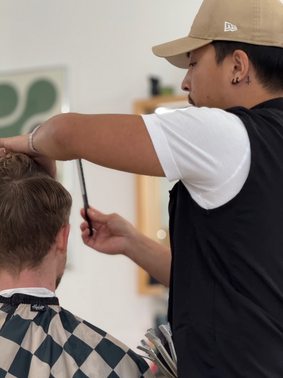 Daniel Lee finishing a client haircut in the chair.